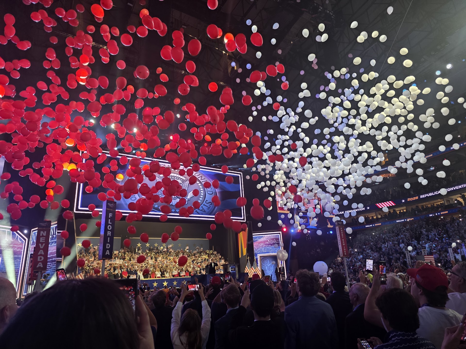 Red and white balloons fall over the stage and crowd at the RNC Midterm Convention in Dallas.